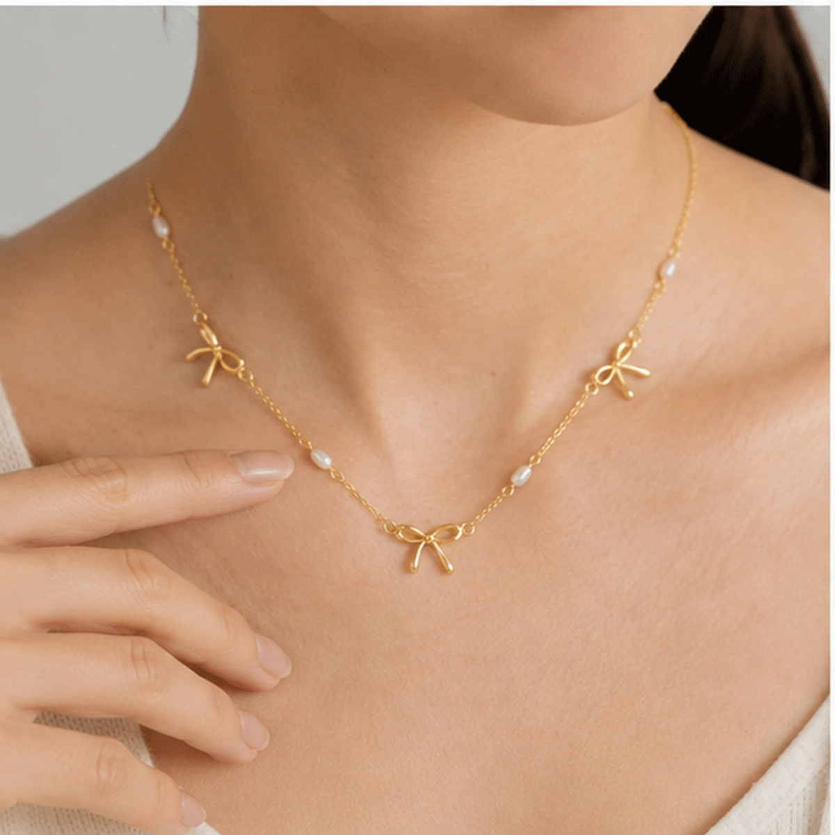 Brass pearl bow necklace available with project specific custom plating options