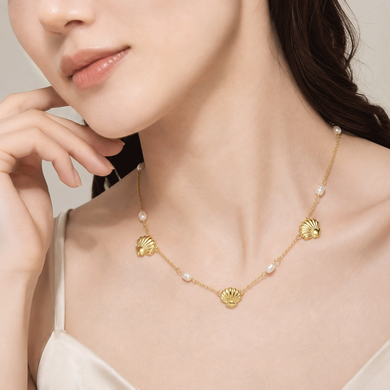 Close-up model view showing the spacing of pearls and shell elements around the neckline - Zhefan Jewelry