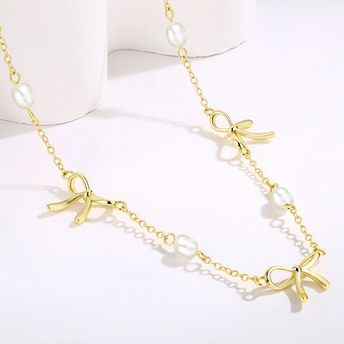 Freshwater pearl bow necklace with polished bow pendant and delicate chain